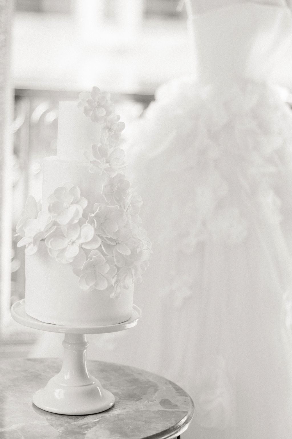 un wedding cake à coté d une robe de mariage